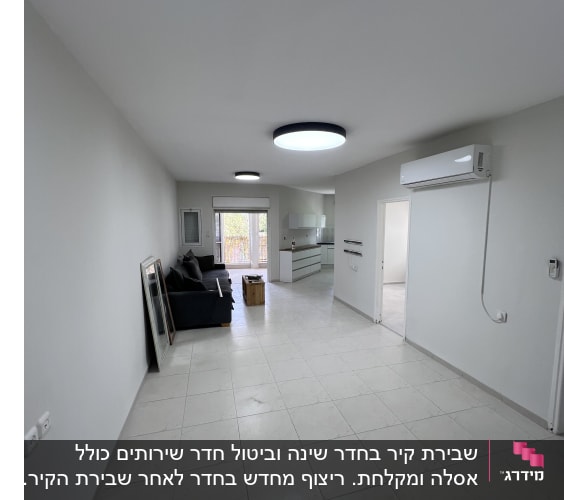 חדר משופץ עם רצפת אריחים, מזגן וספה.